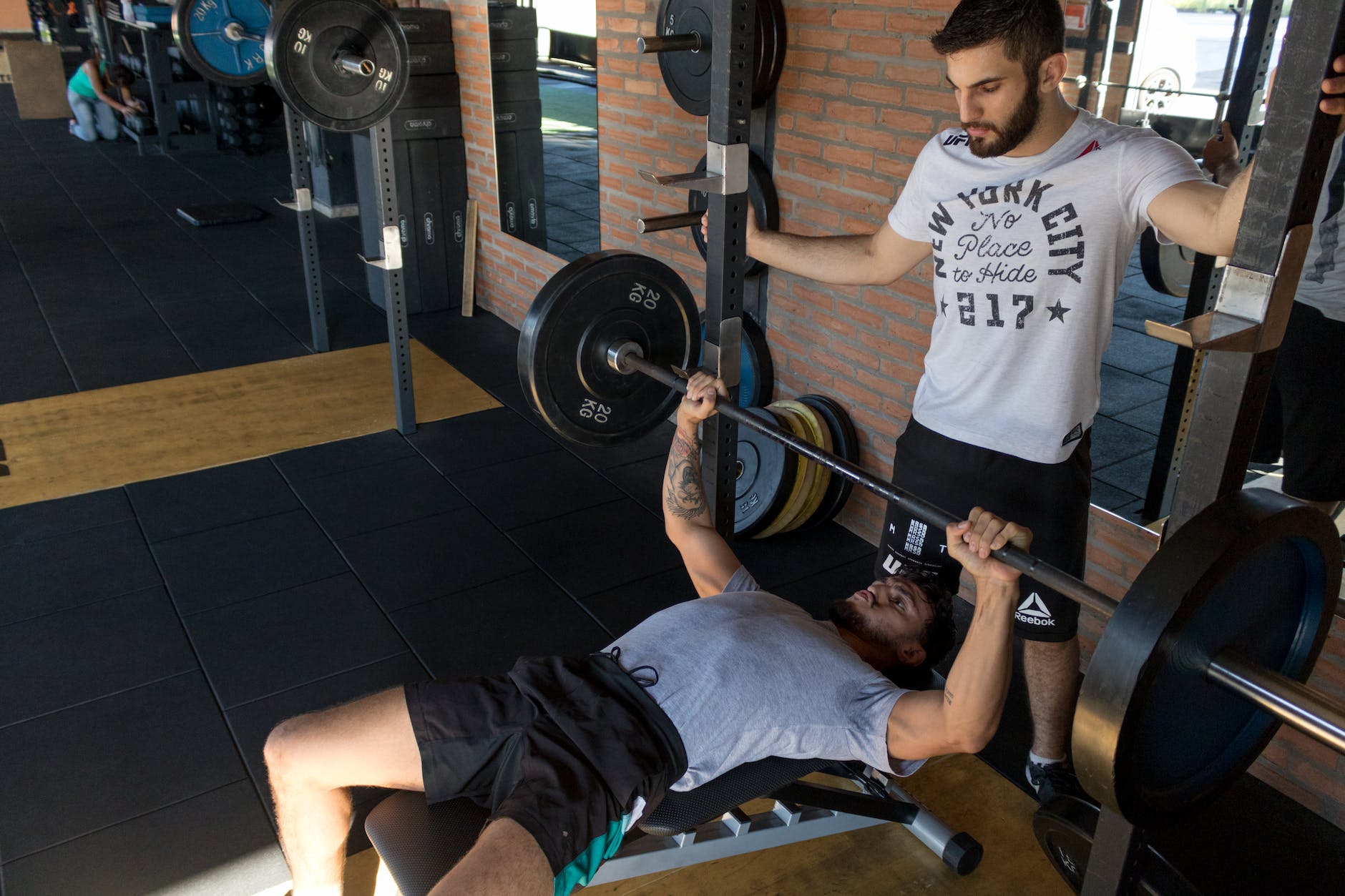 man lying while doing barbell