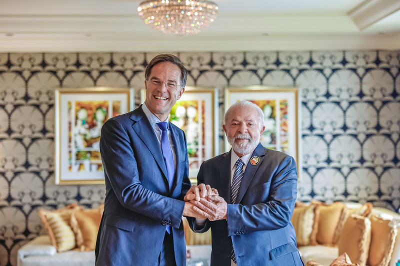 O presidente Luiz Inácio Lula da Silva teve reunião bilateral neste domingo (10) com Mark Rutte, primeiro-ministro dos Países Baixos, após o encerramento da 18ª Cúpula de chefes de Estado e de Governo do G20. Os líderes dos dois países trocaram impressões sobre a Cúpula realizada em Nova Delhi, na Índia, e as perspectivas para a presidência brasileira, entre 1º de dezembro de 2023 e 30 de novembro de 2024. Mark Rutte mostrou entusiasmo com as prioridades do Brasil em seu mandato: combate à fome, pobreza e desigualdade; a transição energética e o desenvolvimento sustentável em suas três dimensões (econômica, social e ambiental), além da reforma do sistema de governança internacional. Por sua vez, Lula apreciou o interesse dos Países Baixos em participar da Cúpula do G20 no Brasil e de auxiliar as forças-tarefa do grupo. A definição da lista de possíveis países convidados ainda está sendo trabalhada. Na conversa, Lula também afirmou que o documento Mapa do Caminho, discutido durante visita de Rutte a Brasília em maio, deverá tornar-se marco das relações bilaterais, e que a transição energética pode ser tema fundamental da cooperação entre os dois países. Nessa área, o interesse principal são os biocombustíveis para o setor marítimo e hidrogênio de baixa emissão. As mudanças climáticas que estão afetando o Brasil e o mundo foram outro tema da reunião. O presidente Lula frisou que esse é um problema sério. Na sessão de abertura da Cúpula do G20 realizada no sábado (09), ele voltou a cobrar ações mais enfáticas dos países desenvolvidos para ampliar o combate global às mudanças climáticas. Os governantes também falaram sobre o acordo em construção entre o Mercosul e a União Europeia. Sob liderança do Brasil, o Mercosul entregou, dias atrás, uma contraproposta ao documento adicional dos europeus. Lula enfatizou que quer um acordo equilibrado, que contribua para o projeto de reindustrialização do Brasil e que preserve o poder indutor que o Estado brasileiro pode exercer por meio das compras governamentais. A relação comercial entre os dois países também foi abordada na reunião. Lula demonstrou satisfação pela escolha da Embraer para fornecer cinco aeronaves C-390 para a Força Aérea dos Países Baixos. Em 2022, a corrente de comércio entre Brasil e Países Baixos foi de 14,7 bilhões de dólares. PARCERIA ESTRATÉGICA — O Brasil constitui tradicional e importante parceiro comercial, bem como é o destino de investimentos importantes. Os Países Baixos são o maior mercado para as exportações brasileiras na Europa, e o quarto maior no mundo, atrás apenas dos EUA, China e Argentina. O já tradicional superávit na balança comercial bilateral aumentou significativamente em favor do Brasil em 2018, quando foram exportados cerca de USD 13 bilhões (5,45% do total das exportações brasileiras) e importados USD 1,6 bilhão — um saldo de USD 11,3 bilhões, o maior das relações comerciais com parceiros europeus. Os principais produtos exportados para os Países Baixos continuam a ser plataformas de perfuração ou de exploração de petróleo, farelo e resíduos da exportação de óleo de soja, tubos de aço, minérios de ferro e celulose. O Brasil importa principalmente combustíveis, produtos manufaturados, e ferro fundido e ferro e aço para construção. O porto de Roterdã é o mais relevante ponto de entrada de bens brasileiros na Europa. COMÉRCIO BILATERAL — A relevância do Brasil traduz-se também no intenso e constante fluxo de investimentos bilaterais. O estoque acumulado de investimentos holandeses no país atingiu cerca de USD 120 bilhões. Somente em 2017, foram cerca de USD 11 bilhões, do conjunto de 75 bilhões que se estima terem sido destinados ao Brasil naquele ano. Grandes empresas daquele país, além de instituições financeiras, têm fortes interesses no Brasil. Registra-se também aumento da presença de empresas brasileiras nos Países Baixos. Petrobras, Embraer, Braskem, Bertin Agropecuária, Cutrale, Perdigão e Seara Foods são algumas das empresas brasileiras com investimentos na região