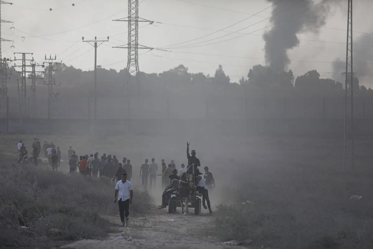 Membros palestinos das Brigadas Izz ad-Din al-Qassam, o braço militar do Hamas, que foram mortos em confrontos na fronteira Gaza-Israel, e os feridos são removidos da área e levados para a Faixa de Gaza, em Gaza, em 7 de outubro 2023 [Mustafa Hassona – Agência Anadolu]