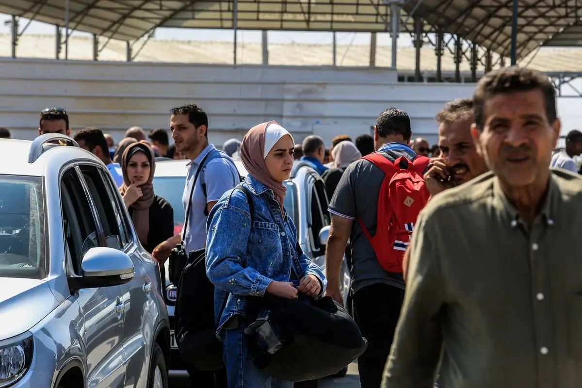 Cidadãos binacionais de Gaza esperam na travessia de Rafah para entrar no Egito, após oito dias de intensos bombardeios israelenses ao território sitiado, 14 de outubro de 2023 [Abed Rahim Khatib/Agência Anadolu]