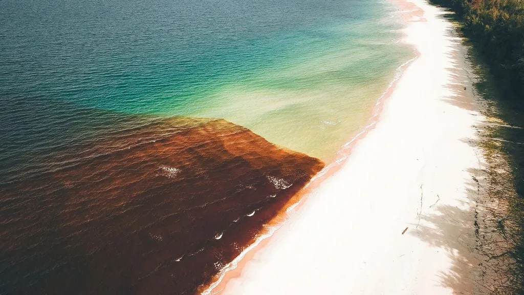 Fenômeno Mar Vermelho ao lado de trecho com a água em tonalidade normal