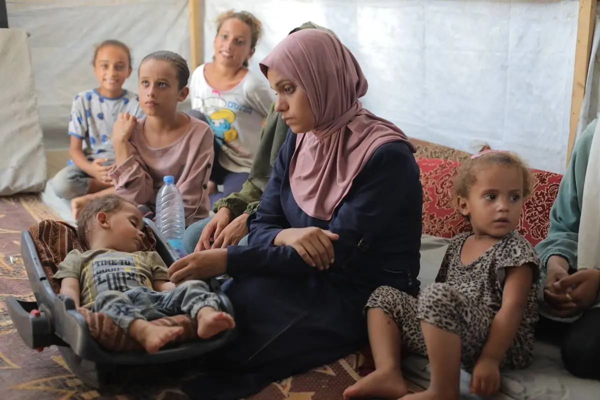 Abdul Rahman Abu al-Jidyen, de 11 meses de idade, primeira vítima da poliomielite na Faixa de Gaza em 25 anos, junto de sua família, em Deir al-Balah, no centro do enclave, em 27 de agosto de 2024 [Hassan Jedi/Agência Anadolu]