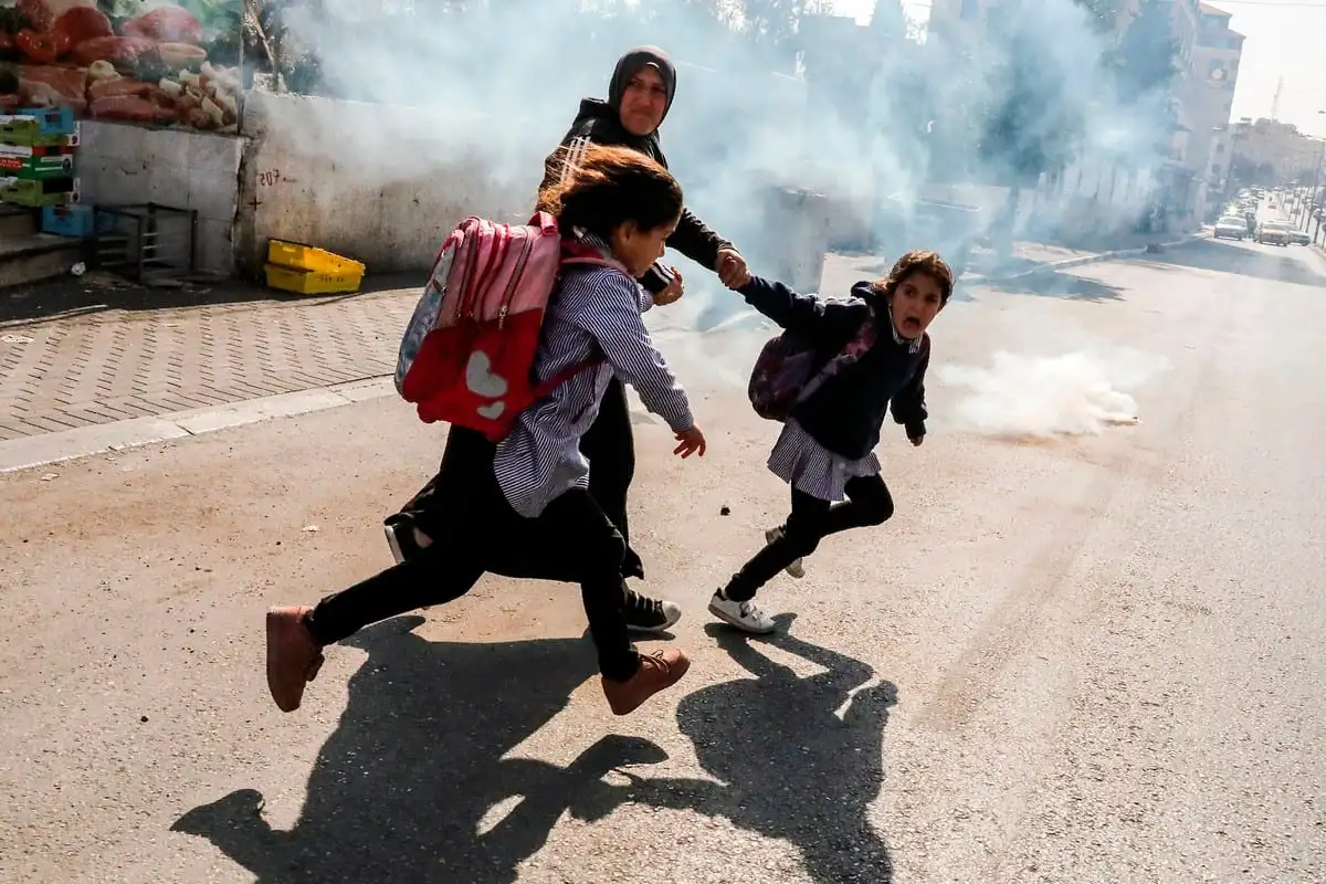 Mulheres e crianças fogem de ataques israelenses na Cisjordânia, em 17 de novembro de 2019 [Hazem Bader/AFP/Getty Images]