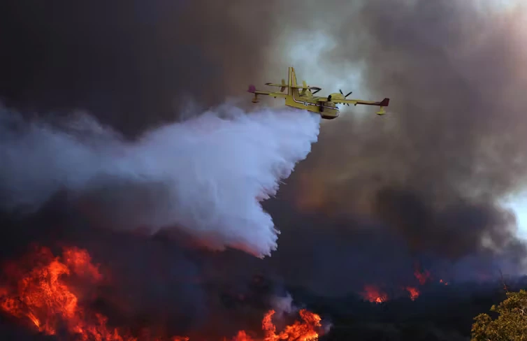 Avião despeja água em um dos incêndios na área de Los Angeles em janeiro de 2025. A água salgada corrói os equipamentos de combate a incêndios e pode prejudicar os ecossistemas. Brian van der Brug / Los Angeles Times via Getty Images