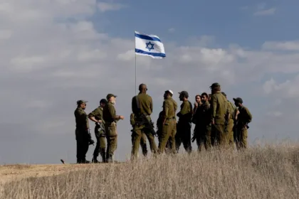 Soldados de Israel hasteiam bandeira perto da fronteira com Gaza, em 5 de dezembro de 2024 [Amir Levy/Getty Images]