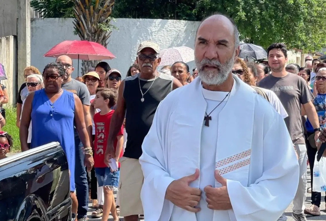 O padre André Luiz Teixeira de Lima caminha ao lado de fiéis em Guaratiba, Rio de Janeiro: o religioso foi impedido de celebrar missa após ataques de grupo extremista – Foto: Reprodução