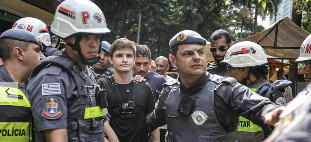 Vereador Lucas Pavanato sai de marcha Transmasculina escoltado por policiais. Imagem: reprodução.