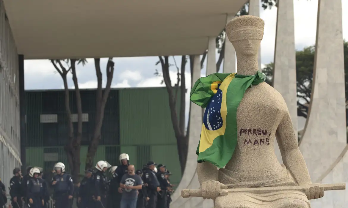 Débora Rodrigues picha a estátua "A Justiça" durante os atos de 8 de janeiro. © Joedson Alves/Agencia Brasil
