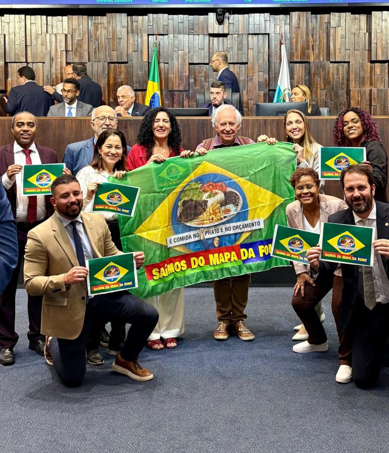 Deputados de oposição exibem bandeira na Alerj para celebrar a saída do Brasil do mapa da fome. Parlamentares bolsonaristas reagem com ironias durante sessão.