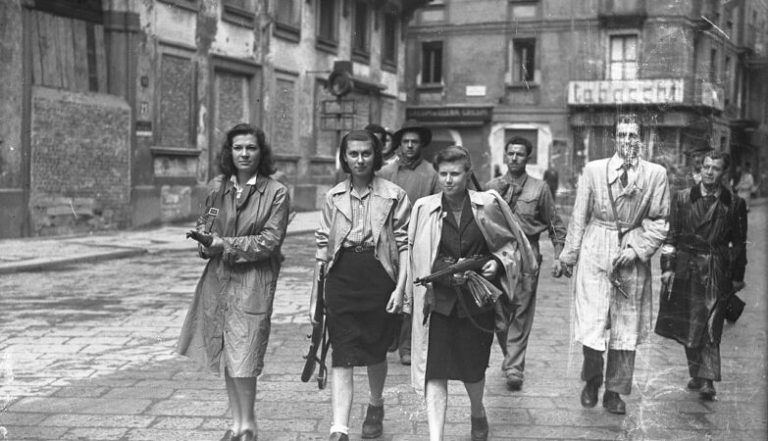 “Partigiane a Brera”: Fotografia, provavelmente encenada, de mulheres guerrilheiras a devolverem as armas aos Aliados em Milão, a 26 de abril de 1945