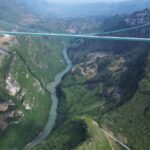 China inaugura a ponte mais alta do mundo: 625 metros acima do rio Beipan, com 2.890 metros de extensão. Obra reduz tempo de viagem de 2 horas para apenas 2 minutos.