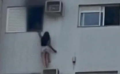 Mulher dependurada em ar-condicionado durante incêndio/Reprodução