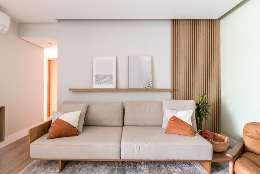 De acordo com a arquiteta Cinthia Claro, há casos em que o objetivo das prateleiras é apenas preencher uma parede vazia e complementar a decoração, tal qual ela realizou nesta sala de estar. Posicionada um pouco acima do sofá, ela cumpre a função de apoiar os quadros | Foto: Erika Waldmann