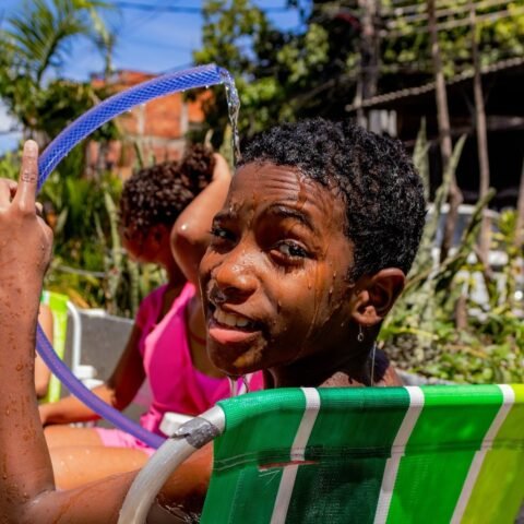 Banho de mangueira no Bela Verão 2025 no Galpão Bela Maré. Fotografia: Thaís Valêncio (Observatório de Favelas)