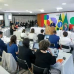 Reunião oficial com bandeiras do Brasil.