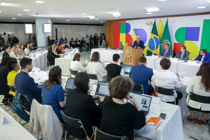 Reunião oficial com bandeiras do Brasil.