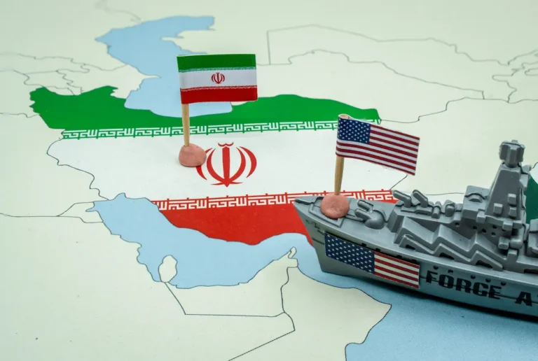 Bandeiras nacionais dos Estados Unidos e do Irã em um mapa geopolítico com um navio de guerra de brinquedo, representando um potencial conflito militar ou tensão diplomática entre os dois países — stock imagem, fotos sem royalties